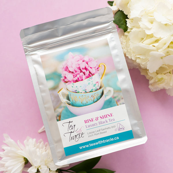 Rise & Shine black tea pouch by Tea with Tracie on a pink background with white flowers