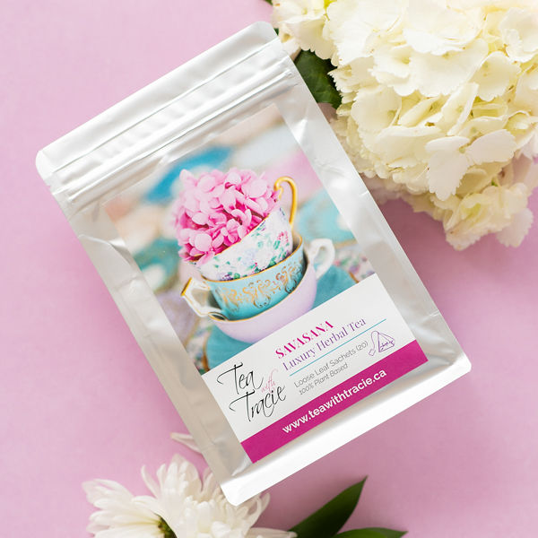 Savasana lemon mint herbal tea pouch by Tea with Tracie on a pink background with white flowers