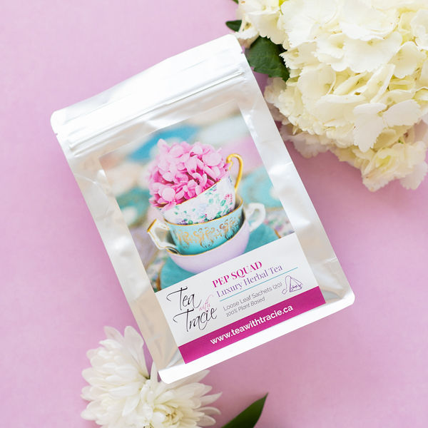 Pep Squad peppermint herbal tea pouch by Tea with Tracie on a pink background with white flowers
